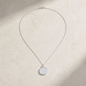 Sterling silver round pendant necklace on pale stone