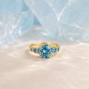 Althea Classic 1ct Round-Cut Blue Sapphire Gold Ring on walnut tabletop
