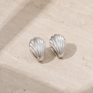 Silver frosted shell huggie hoop earrings on pale stone