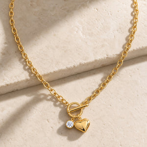 Gold heart pendant lariat necklace with moissanite charm on pale stone