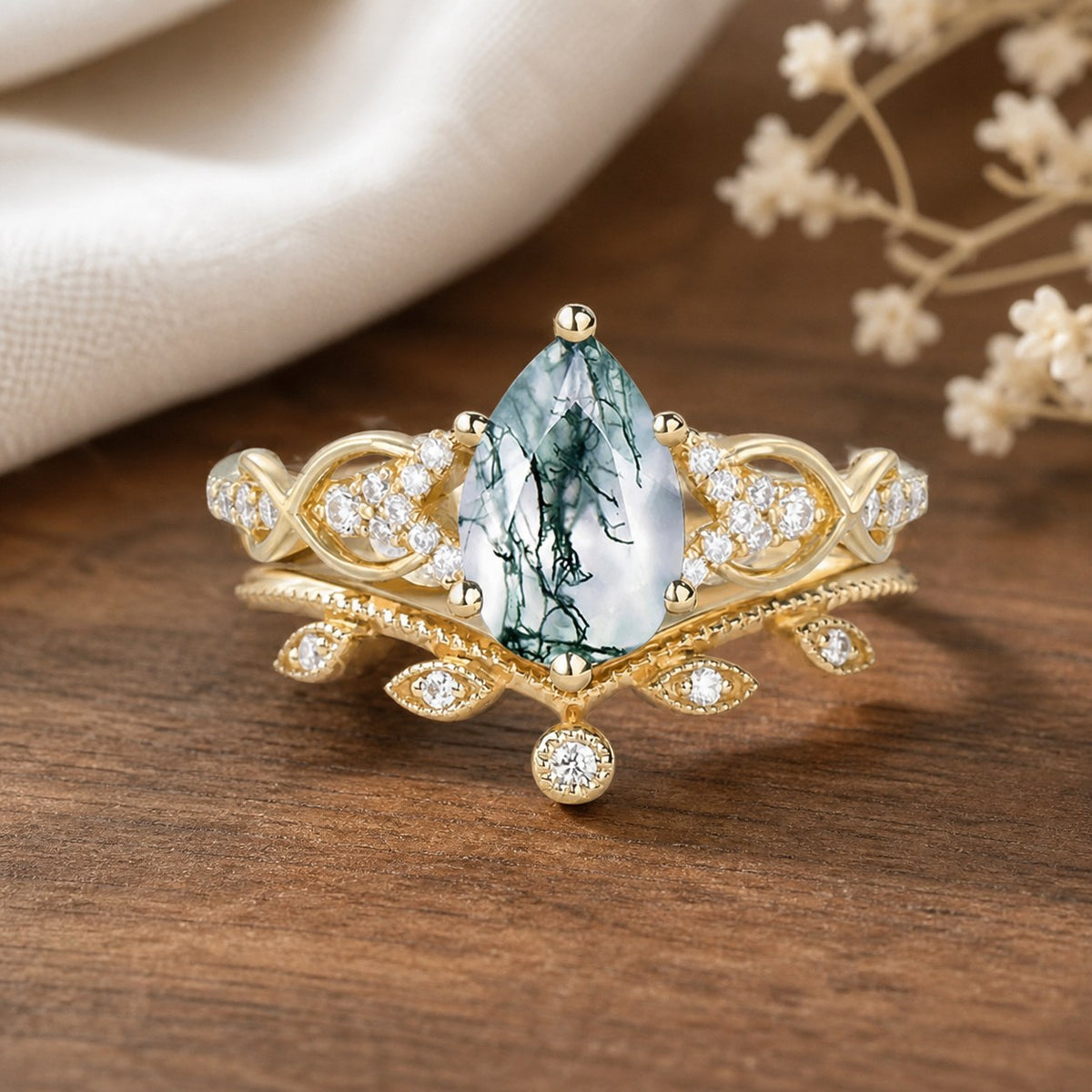 Three-stone hexagon moss agate and kite blue sandstone engagement ring on a natural walnut tabletop