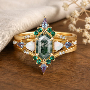 Rosalind’s Tangle pear-cut moss agate vine engagement ring set on a natural walnut tabletop
