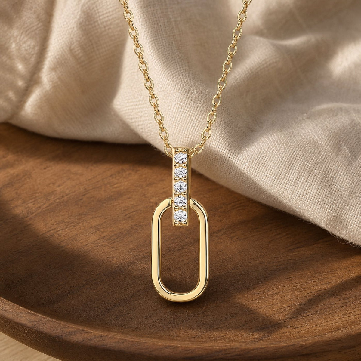 Chic oval link paper clip pendant necklace in silver moissanite on warm walnut