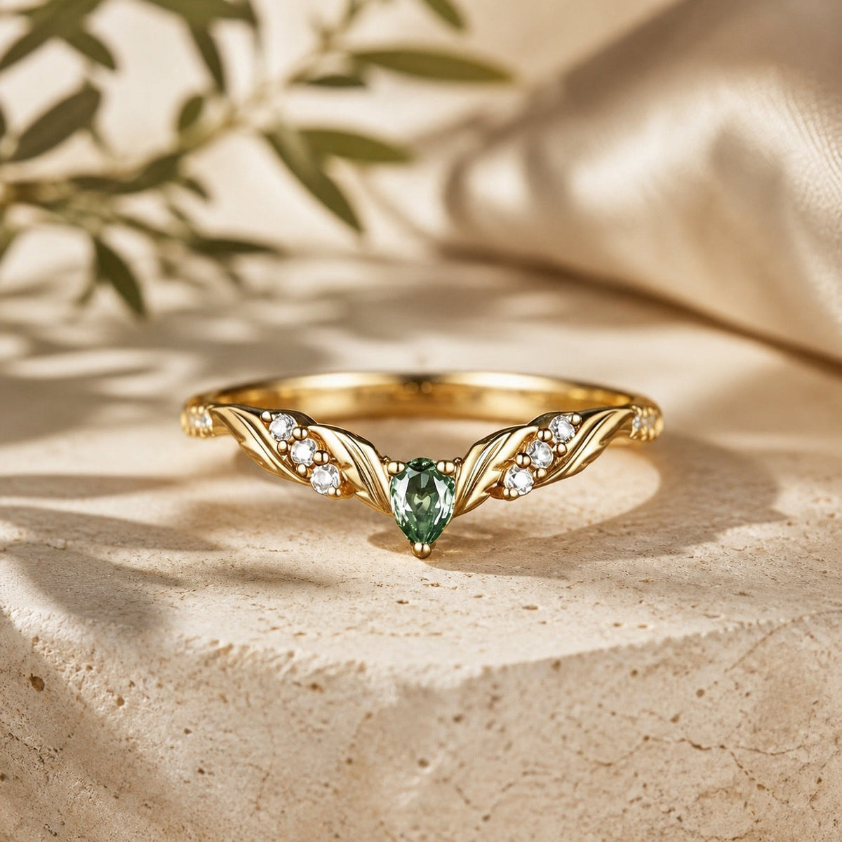 Green sapphire and moissanite leaf-inspired curved wedding band on warm stone