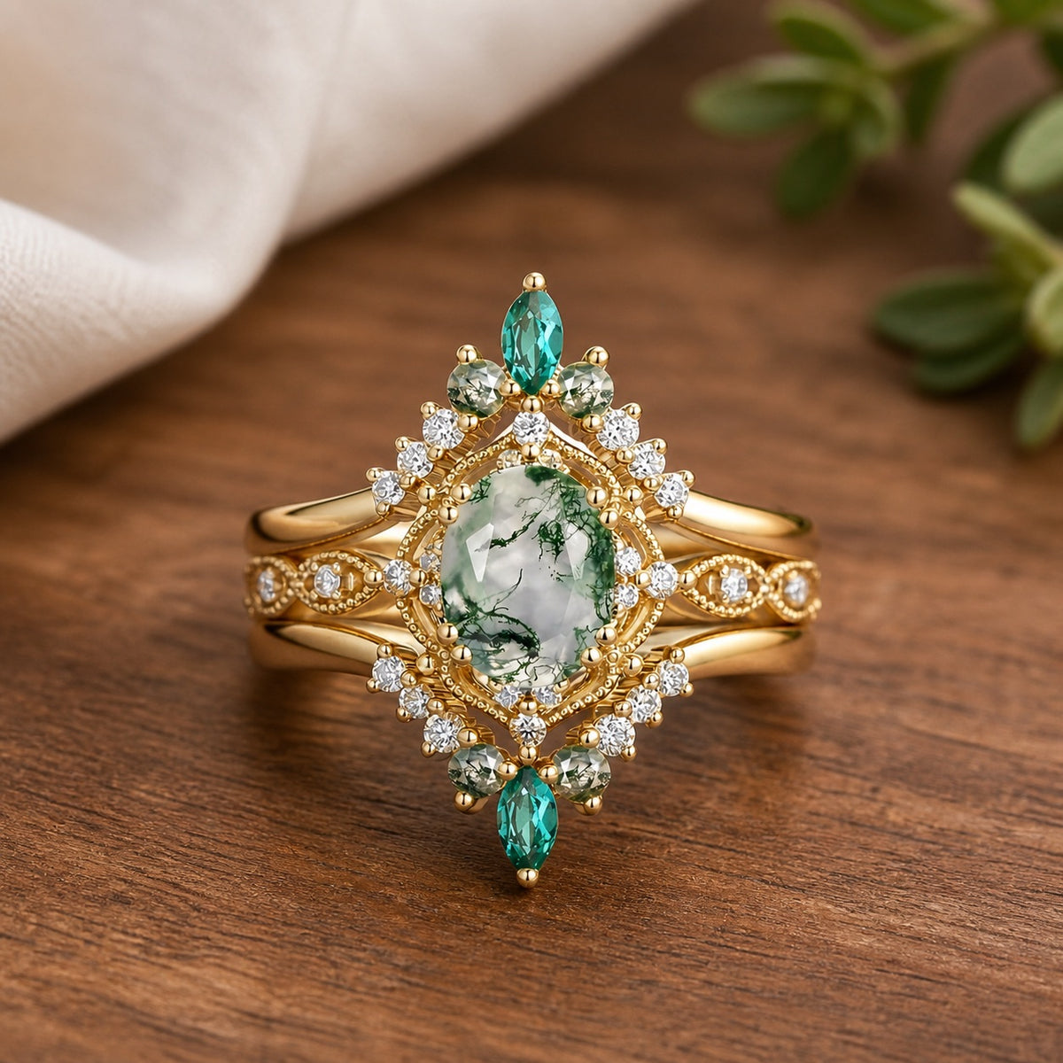 Alexandra's Heritage vintage oval moss agate and lab emerald bridal set on a warm walnut surface
