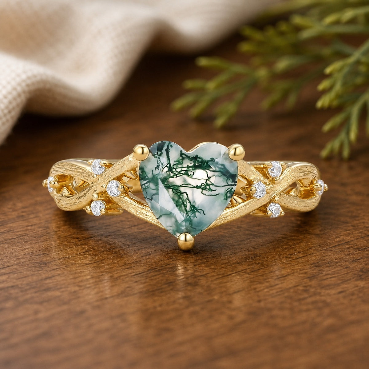 Alexandra's Heart heart-cut moss agate engagement ring on a warm walnut tabletop