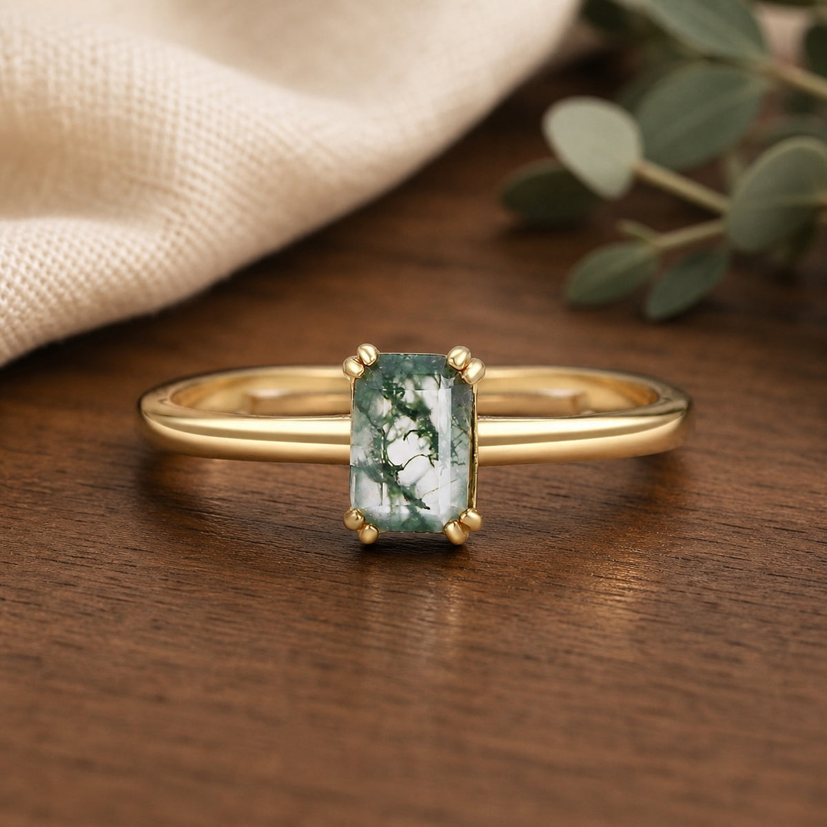 emerald-cut moss agate solitaire engagement ring in a warm walnut jewelry setting