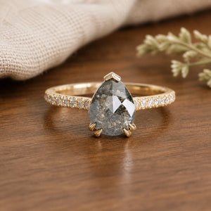 Astrid's Stardust 2ct Pear Cut Salt and Pepper Moissanite Pave Engagement Ring on walnut tabletop