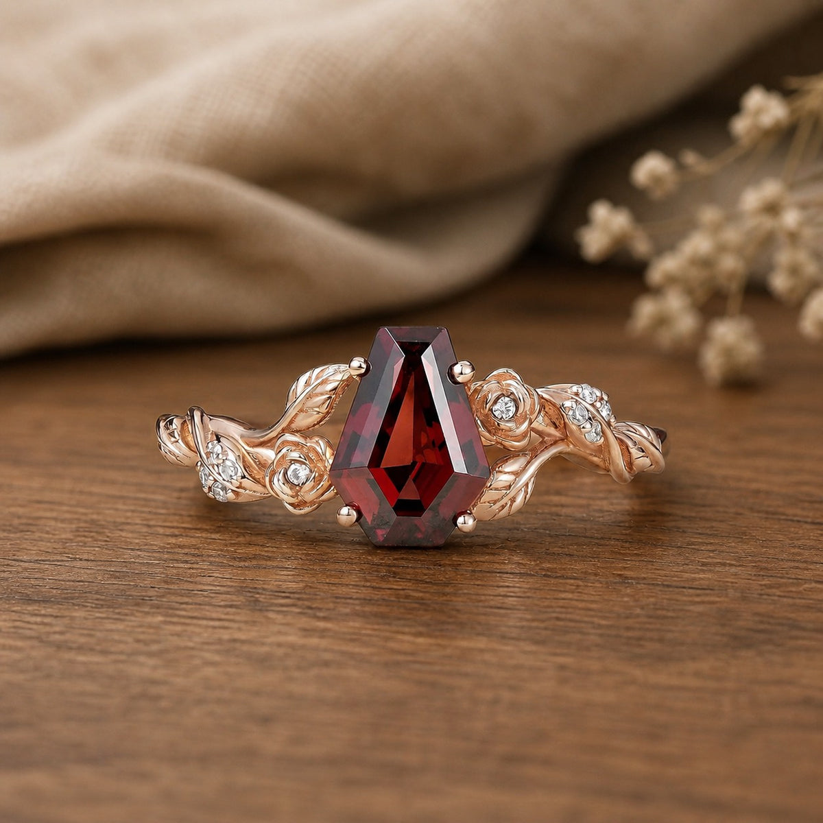 Coffin Cut Garnet Leaf and Flower Engagement Ring on walnut tabletop