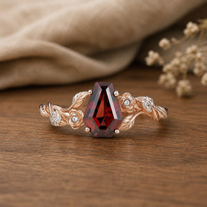 Coffin Cut Garnet Leaf and Flower Engagement Ring on walnut tabletop