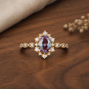 Delicate Oval Alexandrite Cluster Engagement Ring on walnut tabletop