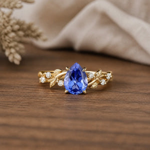 Cornflower Sapphire Leaf Engagement Ring on walnut tabletop