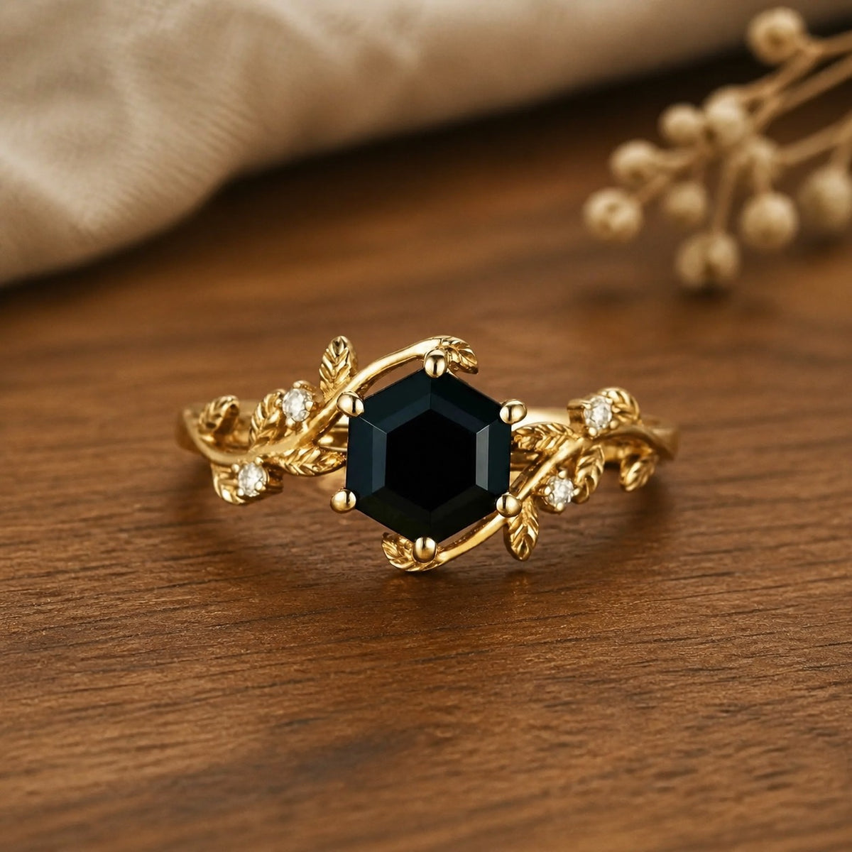 Mistletoe Inspired black onyx leaf engagement ring on a warm walnut tabletop