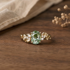 Leaf Inspired 1.5ct lab-grown green sapphire leaf engagement ring on a warm walnut tabletop
