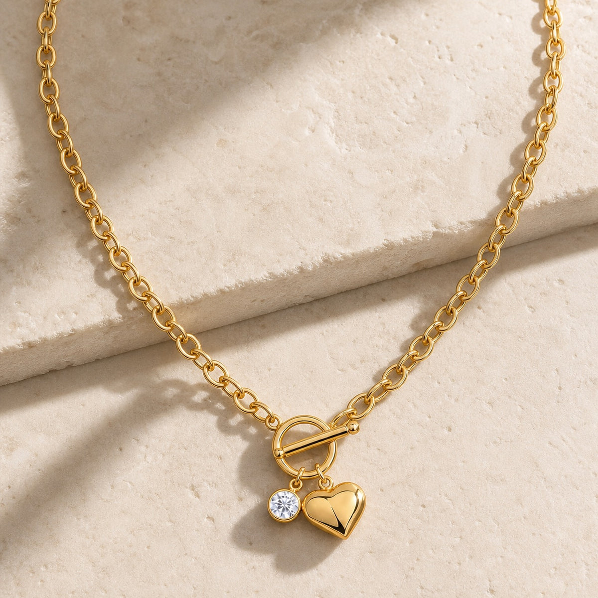 Gold heart pendant lariat necklace with moissanite charm on pale stone