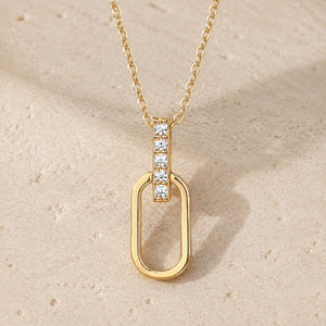 Gold oval-link moissanite pendant necklace on pale stone