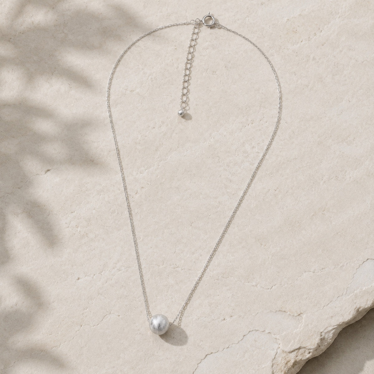 Silver chatoyancy ball-bead necklace with round pendant on pale stone